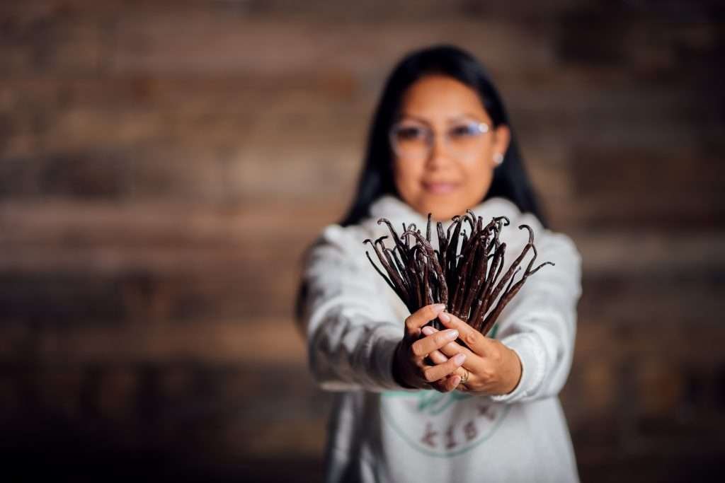 Andréa hält ein Bündel dunkler Bourbon-Vanilleschoten in die Kamera